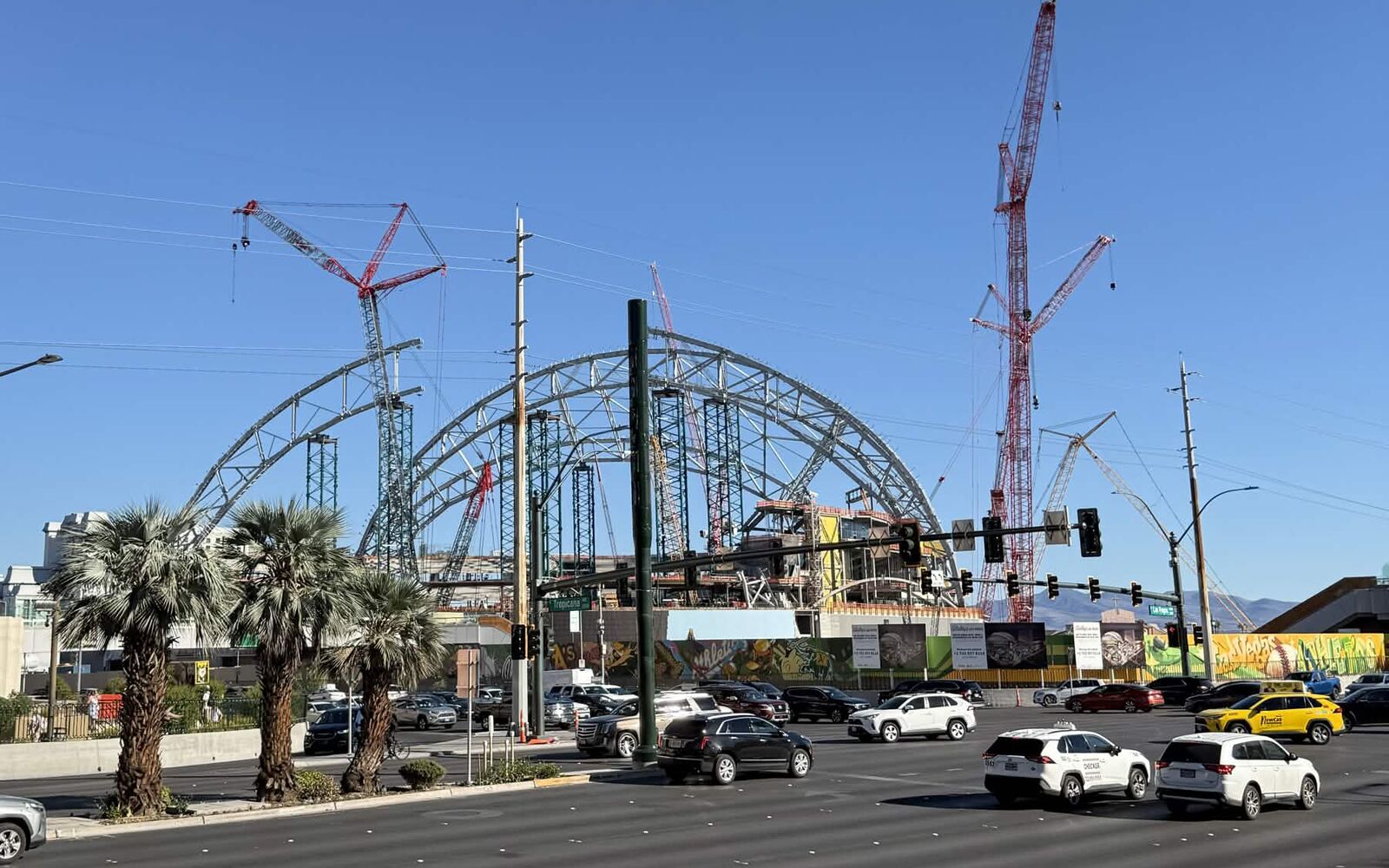 Palm trees and Strip traffic in front of the Las Vegas Athletics ballpark roof arches